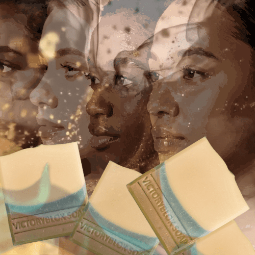 VICTORYBLOKS Patchouli Sea & Earth soap bar with a brown base, blue wave, and cream top, displayed with faces of women from diverse ethnic backgrounds, resting on patchouli leaves above a stream. An inclusive, moisturizing bar made with olive oil, coconut oil, rhassoul clay, indigo powder, and patchouli essential oil for gentle cleansing, suitable for all skin types.
