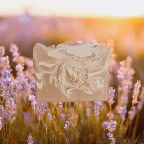 VICTORYBLOKS LAVENDER HOLLOW soap bar with creamy white swirls in a pink base, placed in a field of lavender flowers. Crafted with olive oil, coconut oil, rose clay, and lavender essential oil for a gentle, aromatic cleanse.