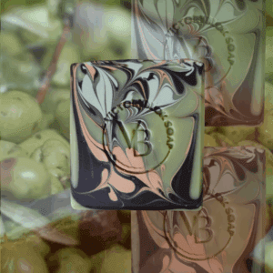 VICTORYBLOKS Cottage Clay soap bar with swirls of brown, green, and red clay, set against a background of vibrant olives. Made with olive oil, coconut oil, clays, lemon and ylang ylang essential oils for a gentle, moisturizing cleanse.