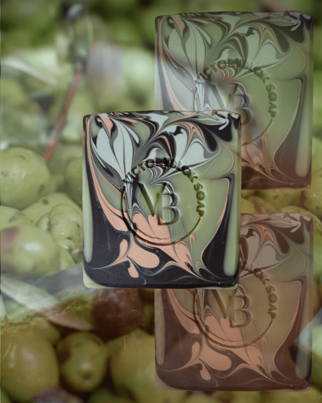 VICTORYBLOKS Cottage Clay soap bar with swirls of brown, green, and red clay, set against a background of vibrant olives. Made with olive oil, coconut oil, clays, lemon and ylang ylang essential oils for a gentle, moisturizing cleanse.