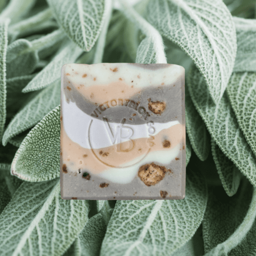 VICTORYBLOKS Sage Ember Soap bar with pastel layers of sage green, brown, white, and salmon pink, speckled with Black African Soap Chips to resemble stones in earth. Made with olive oil, coconut oil, clary sage, lavender, and cinnamon essential oils for a gentle, moisturizing cleanse.